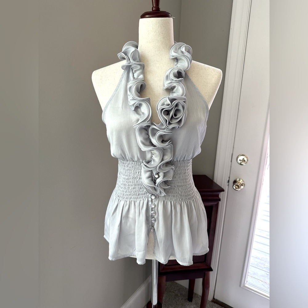 Silvery- grey, low cut, sleeveless top - full of frills - pearly buttons.